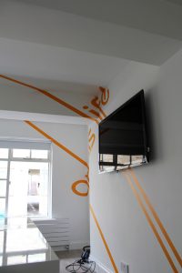 anamorphic graphics with writing on the wall and a tv