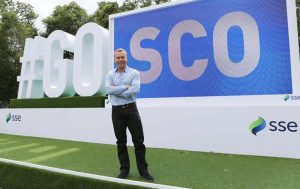 Sir Chris Hoy standing in front of the #go sco signs for the 2014 commonwealth games