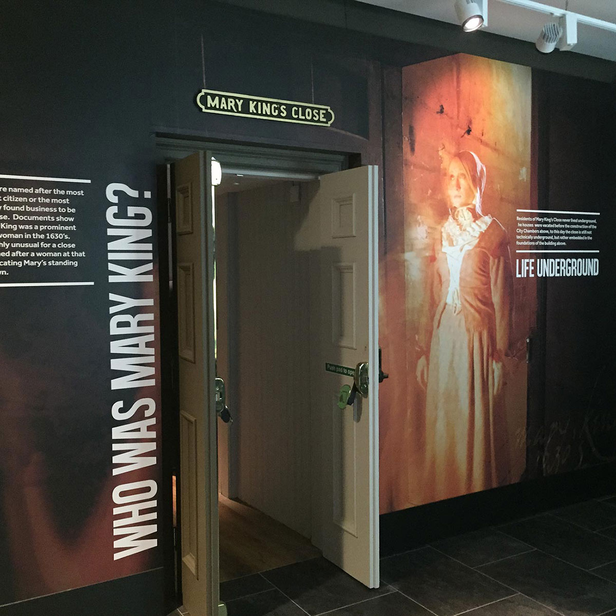 mary kings close entrance with information and images on the wall and an open door