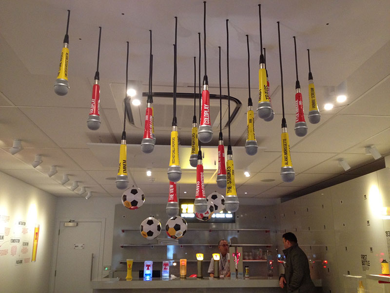 microphone hanging from the ceiling with rock bands named on them and the bar in the background