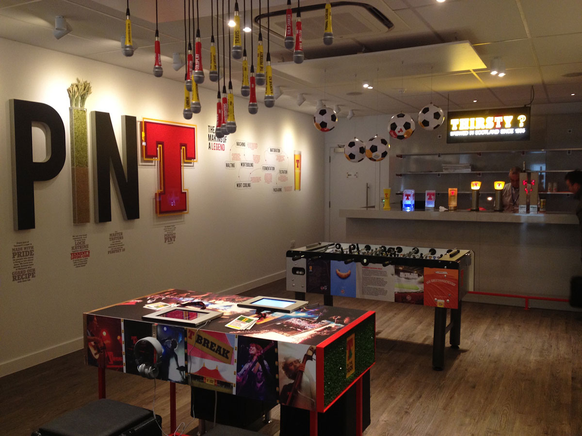 tennents display with microphones from the ceiling, table football and a bar in the background