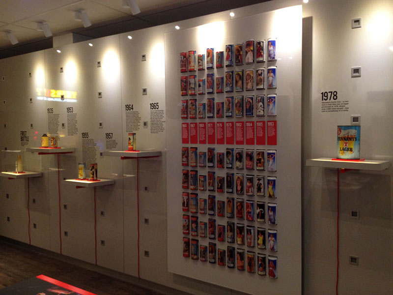 tennents brewery wall display with different styles of beer cans through the years