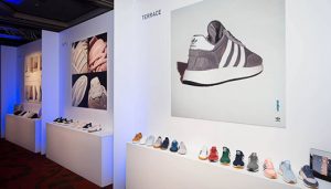 wall with pics of adidas trainers and some shoes lined up in a row below