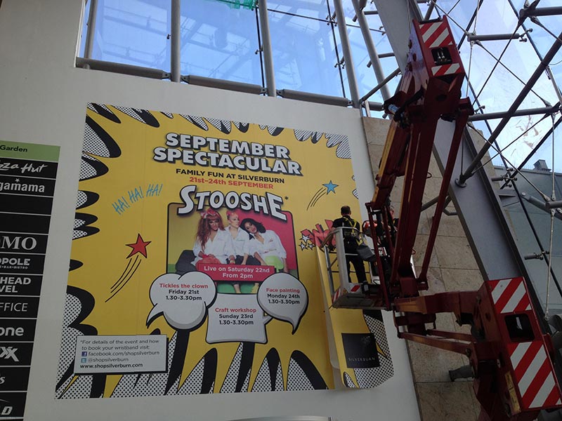 graphics being added to a wall to advertise a children's event