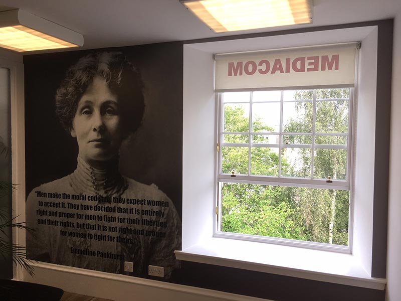 Office Interior with some text and picture on the wall and an open window 