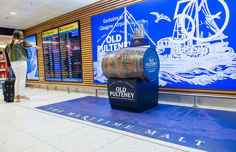 old pulteney barrel display with airport departure boards nearby 