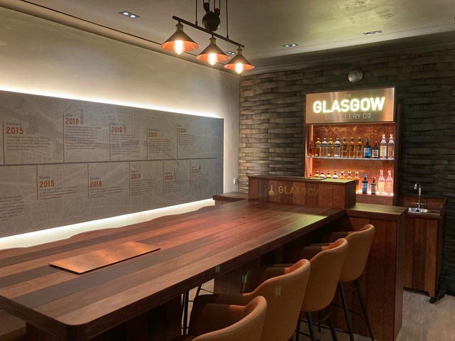 tasting room table from the side with bar in the background