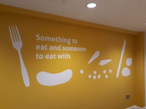 painted wall with message - something to eat and someone to eat with