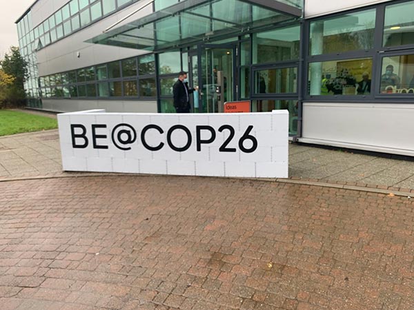be @ cop26 sign and outside main entrance